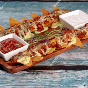"A plate of crispy nachos topped with melted cheese, jalapeños, sour cream, and a sprinkle of fresh cilantro, ready to be enjoyed."