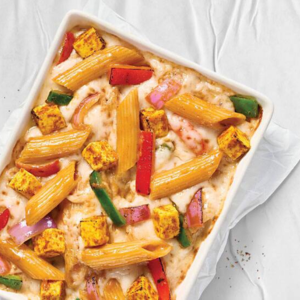 "A plate of creamy pasta topped with fresh herbs, grated cheese, and a rich sauce, served in a beautifully arranged dish."