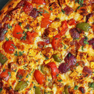 "Close-up of a freshly baked pizza with melted cheese, colorful vegetables, and savory toppings on a golden, crispy crust."
