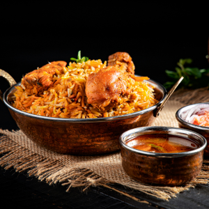 "A fragrant plate of biryani, with perfectly cooked rice, tender meat, and a blend of aromatic spices, garnished with fresh herbs and fried onions."